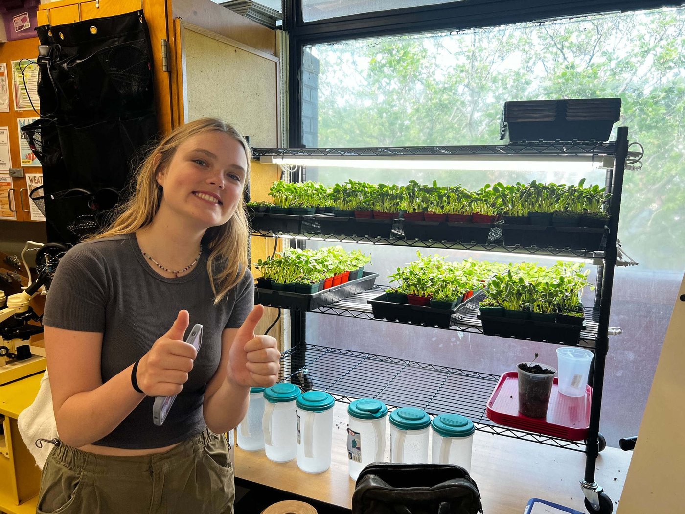 A Boston teacher and students gathered around their classroom grow lab