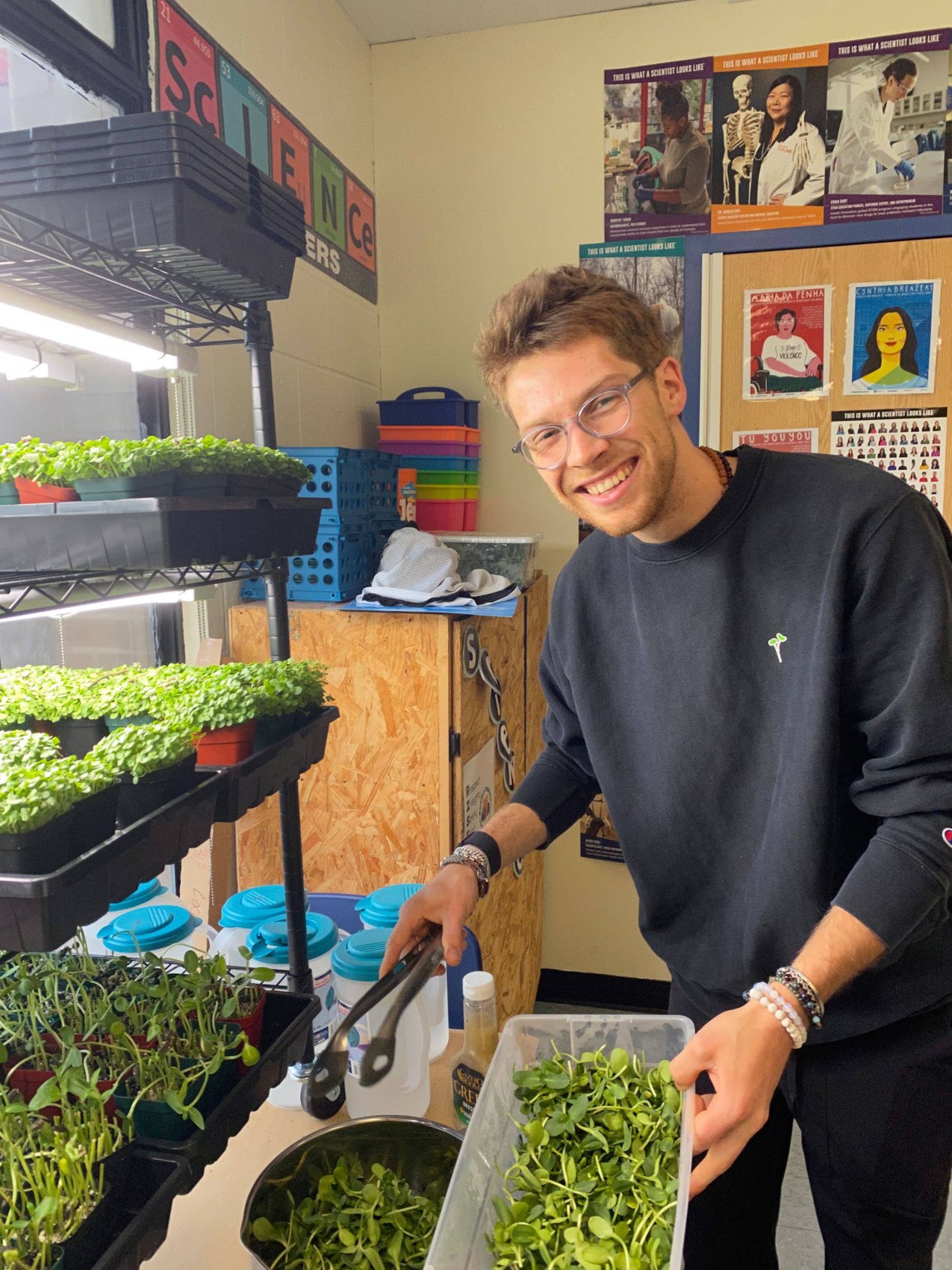 Oliver, BYFP's founder, harvesting sunflower microgreens beside a classroom grow lab