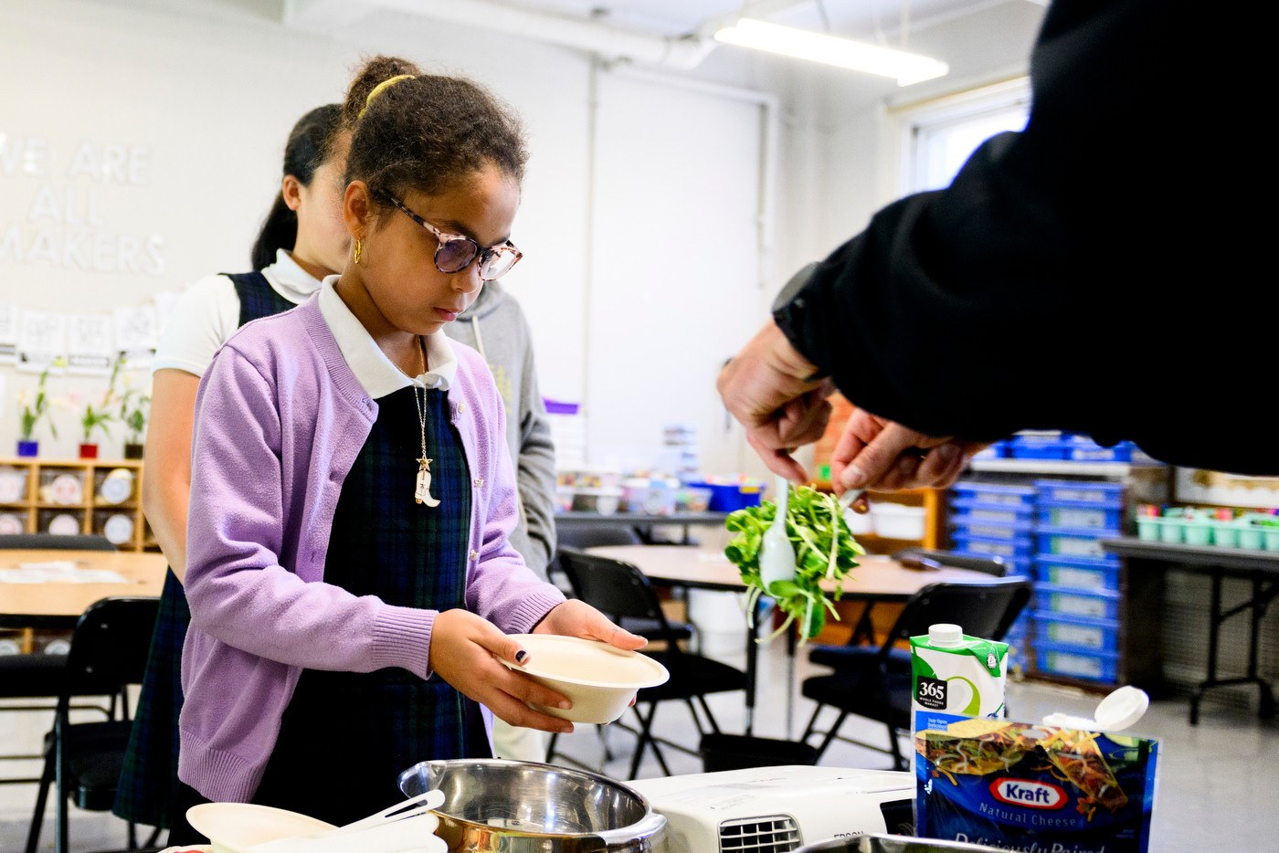 A Boston student adding freshly grown microgreens to her bowl